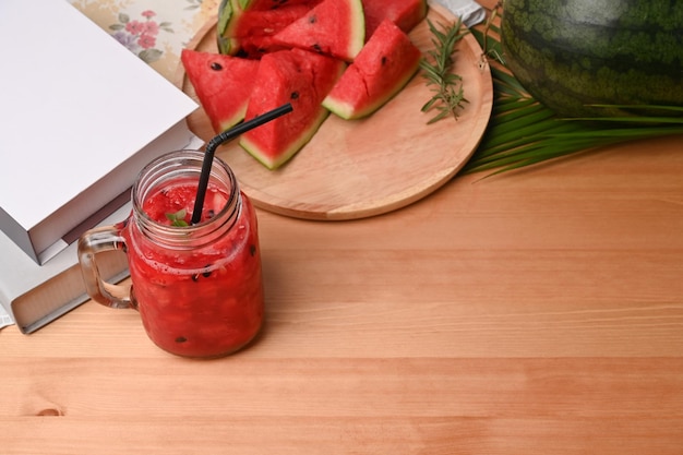 Freshly smoothie in glass jar with watermelon slices on wooden background