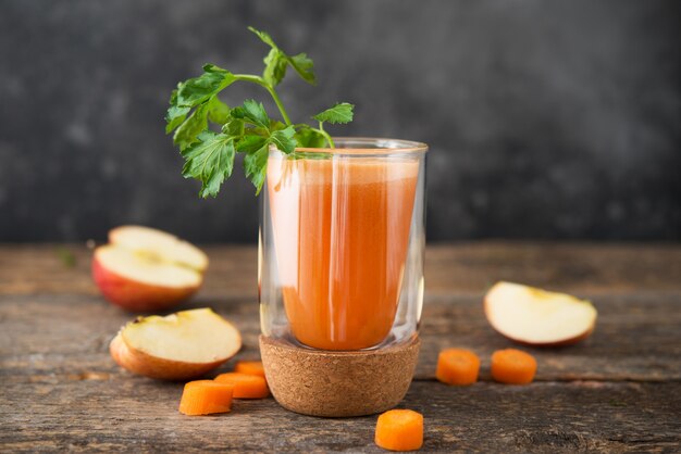 Freshly squeezed apple carrot juice with fresh parsley in a glass