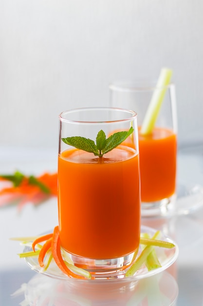 Succo di carota appena spremuto con sedano, orientamento verticale