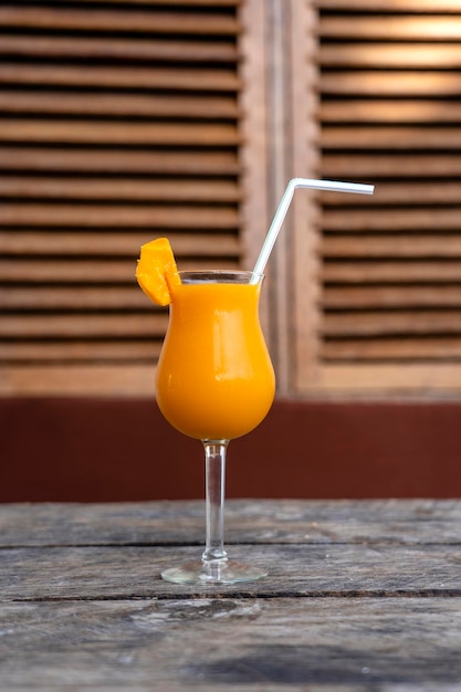 Freshly squeezed juice from mango in a glass goblet Close up