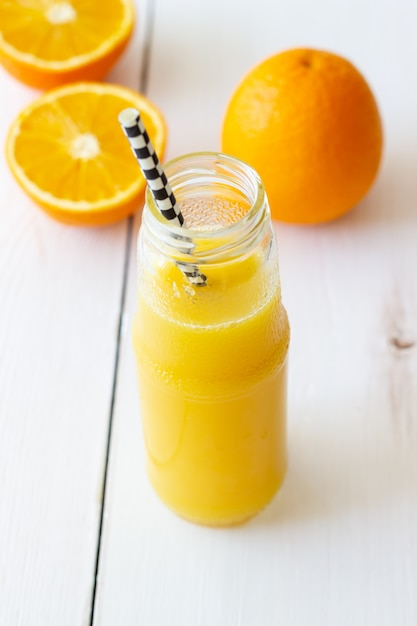 白い背景の上の絞りたてのオレンジジュース。健康的な食事。ダイエット。ベジタリアンフード。