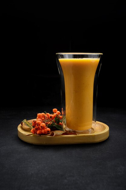 Freshly squeezed pumpkin juice with mountain ash in a glass