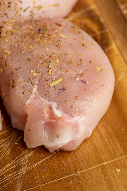 洗いたての皮を剥いた鶏肉のフィレに塩とスパイスを加えて調理する準備ができています。