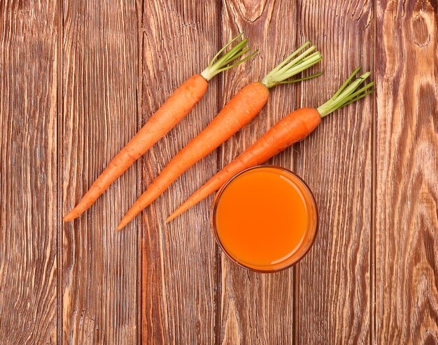 Freshly washed whole carrots on old wooden table.top view