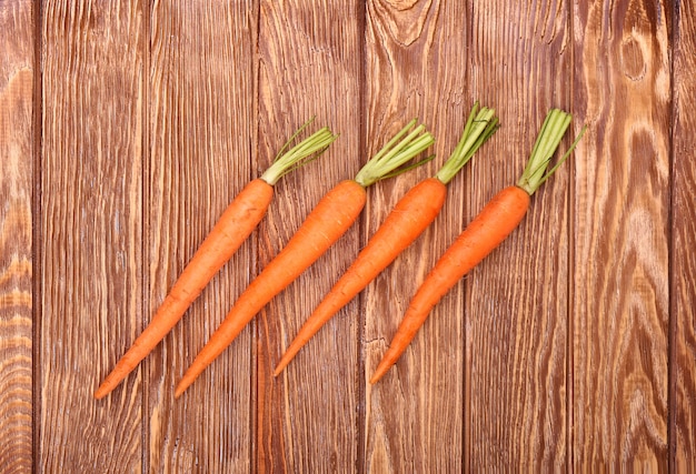 Freshly washed whole carrots on old wooden table.top view