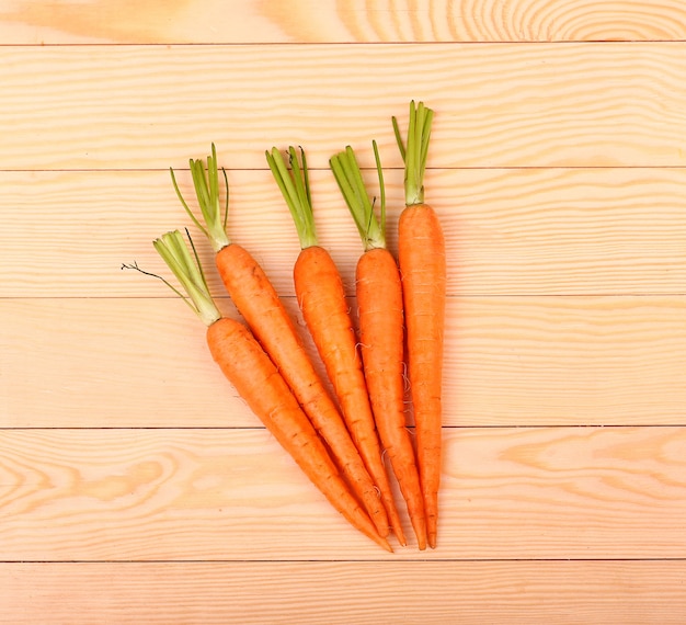 Freshly washed whole carrots on old wooden table