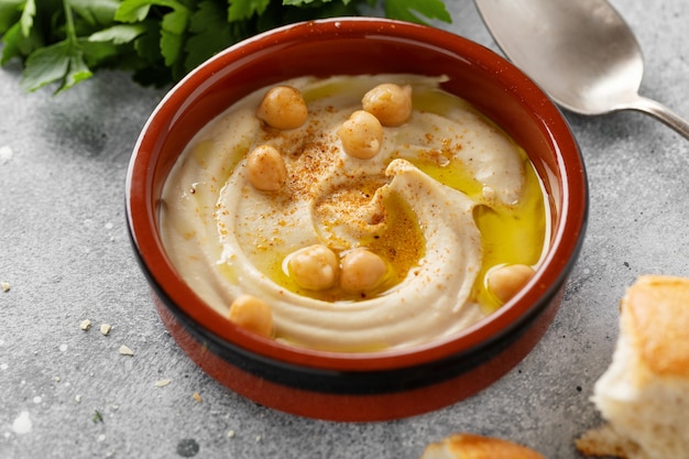 Freshmade oriental classic hummus served in bowl on the table. Closeup