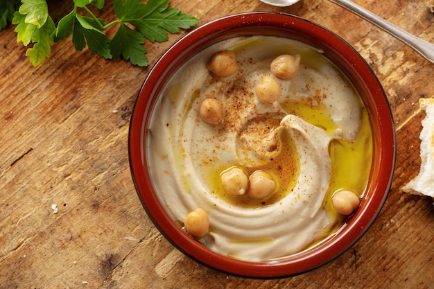 Freshmade oriental classic hummus served in bowl on the table.