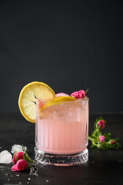 Коктейль свежести с розовым джином и лимоном на черном фоне