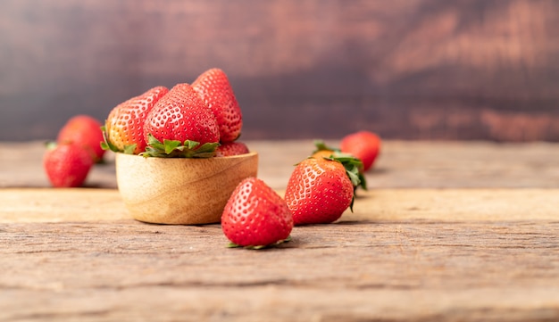 Freshness ripe strawberries are in a wooden bowl placed on the table