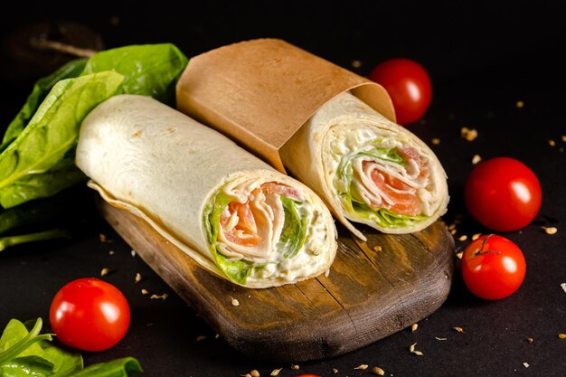 Freshroll shawarma with chicken meat, avocado, standing and lying in a paper container, cutting