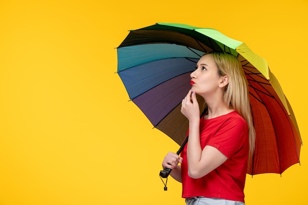 Frevo cute blonde girl celebrating brazilian festival thinking of something with umbrella