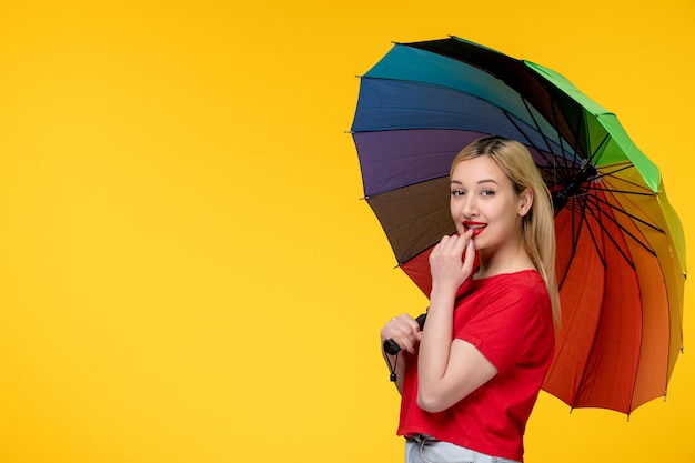 Photo frevo cute blonde girl celebrating brazilian festival touching lips and holding umbrella