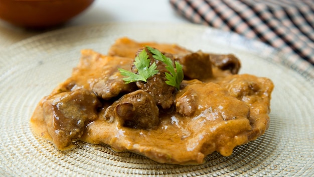Fricando Veal cooked with sauce, vegetables and mushrooms. Typical Spanish tapa recipe.