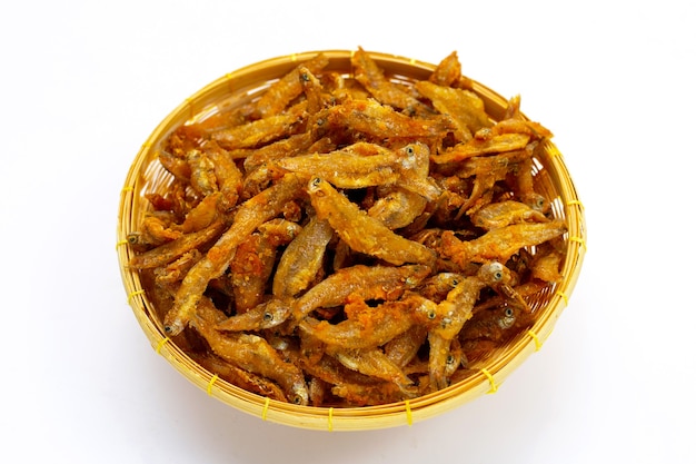 Fried Anchovies in bamboo basket on white background.