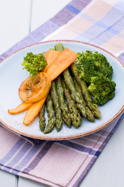 Foto asparagi fritti con broccoli, limone e carota.