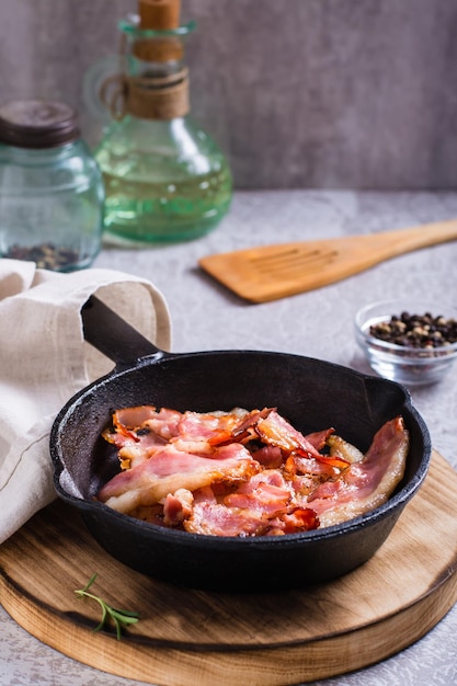 Fried bacon in a pan ready for dinner on the table Vertical view