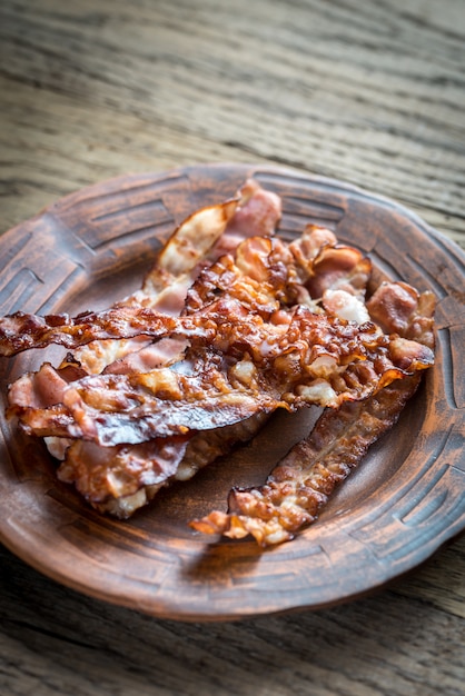 Photo fried bacon strips on the plate