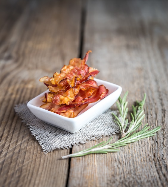 Fried bacon strips with fresh rosemary