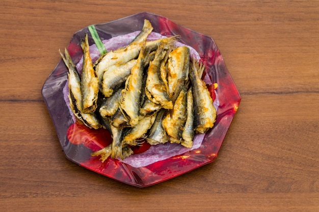 Fried baltic herring on a plate on wooden background