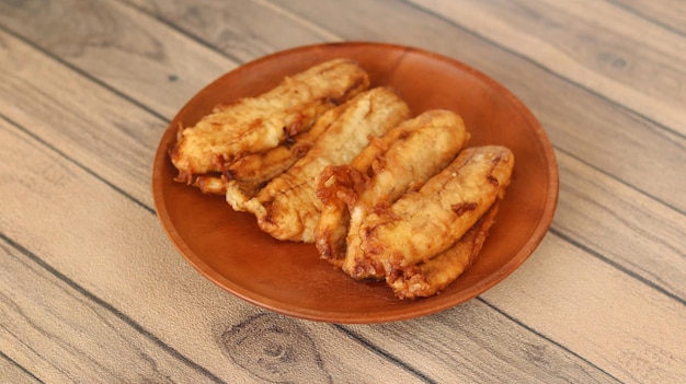 Fried bananas on a wooden plate isolated on wooden background Pisang goreng