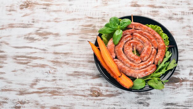 Жареные сосиски барбекю со свежими овощами на деревянном фоне Вид сверху Копией пространства