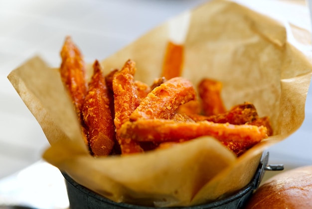 Fried batata in a bowl on wooden background