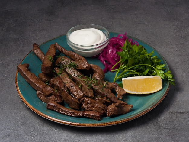 Fried beef liver with sour cream sauce and herbs