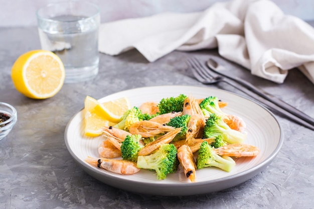 Fried broccoli and shrimp on a plate on the table Healthy vegetarian food