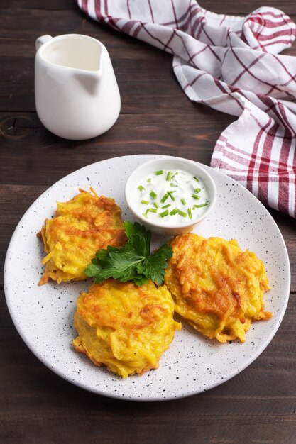 Fried cakes of grated potatoes on the plate with sauce