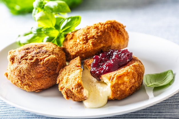Fried camembert or brie cheese with cranberry jam and basil.