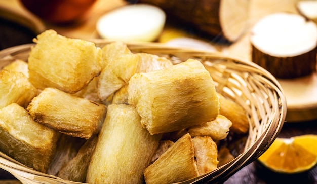 Fried cassava root served peeled and fry Piece of raw cassava in the background homemade food from south america of indigenous origin brazilian restaurant food