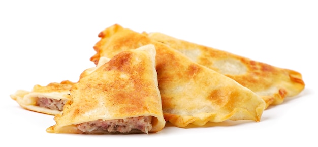 Fried cheburek whole and half close-up on a white plate. Isolated