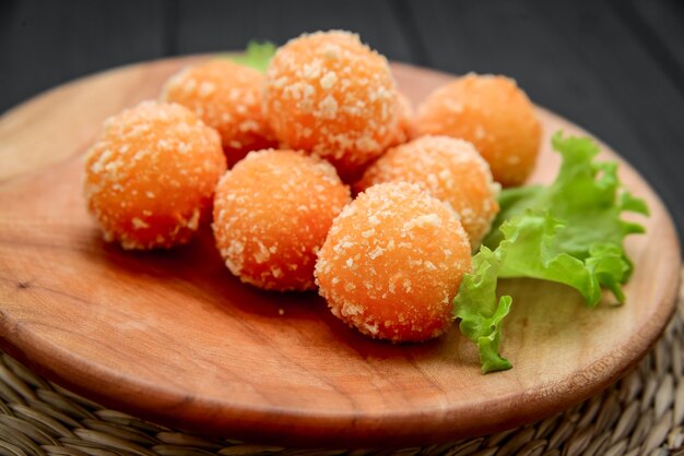 Fried cheese ball, cheese nuggets on a wooden plate