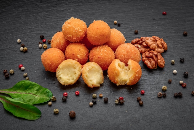 Photo fried cheese ball, cheese nuggets on a wooden plate