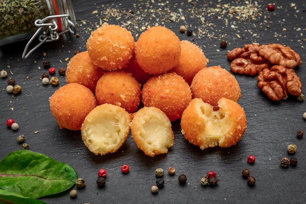 Fried cheese ball, cheese nuggets on a wooden plate