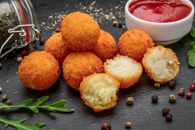 Fried cheese ball, cheese nuggets on a wooden plate