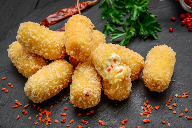 Sfera di formaggio fritto, pepite di formaggio su un piatto di legno