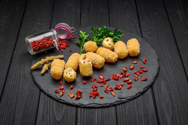 Fried cheese ball, cheese nuggets on a wooden plate