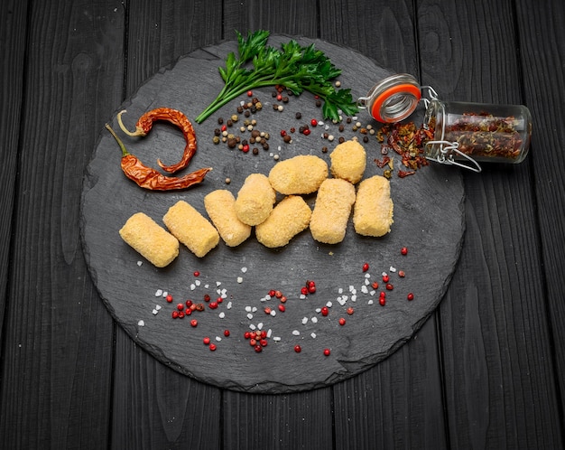 Fried cheese ball, cheese nuggets on a wooden plate