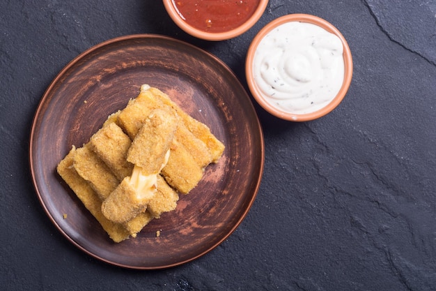 Fried cheese finger with sauces and parsley