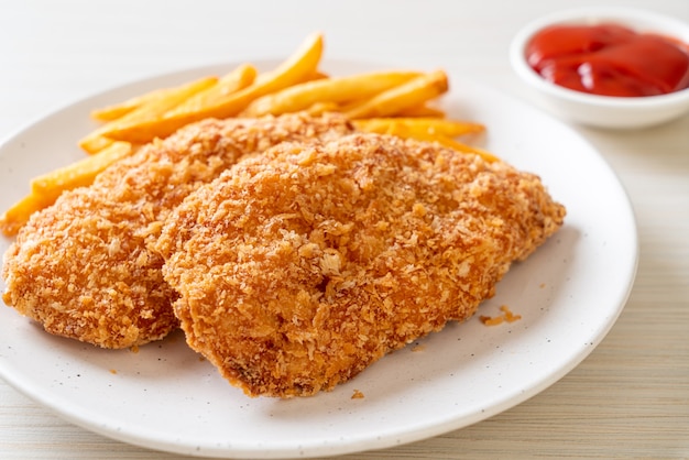 fried chicken breast fillet steak with French fries and ketchup