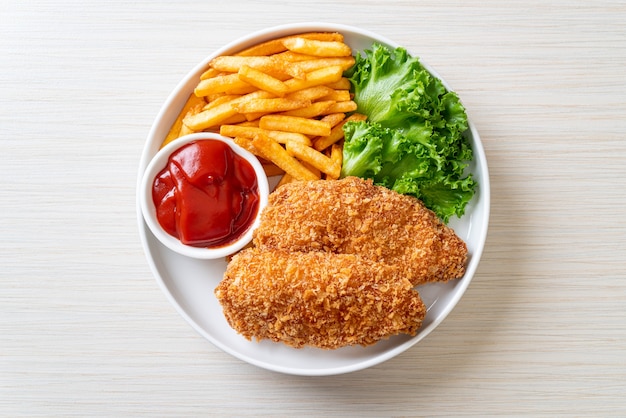 fried chicken breast fillet steak with French fries and ketchup