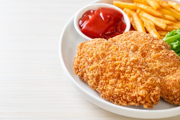 fried chicken breast fillet steak with French fries and ketchup