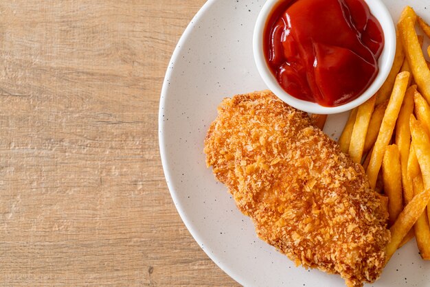 fried chicken breast fillet steak with French fries and ketchup