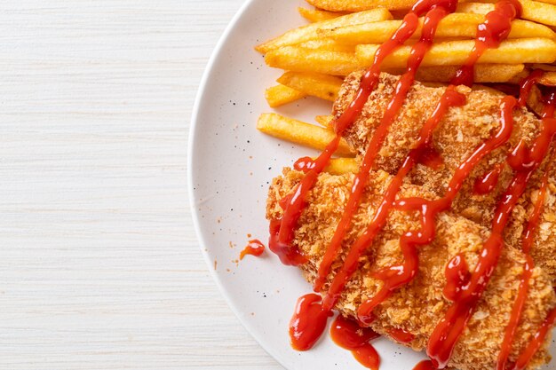 fried chicken breast fillet steak with French fries and ketchup