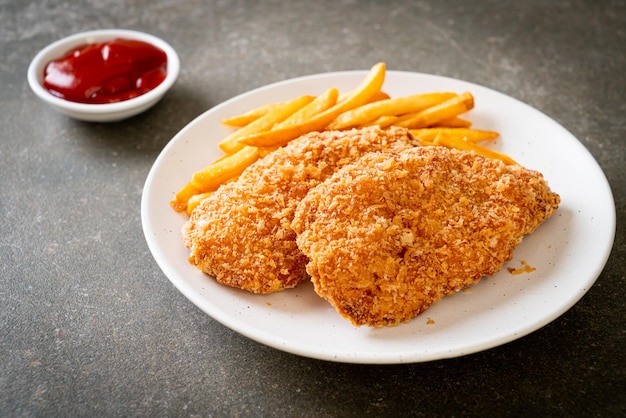 fried chicken breast fillet steak with French fries and ketchup