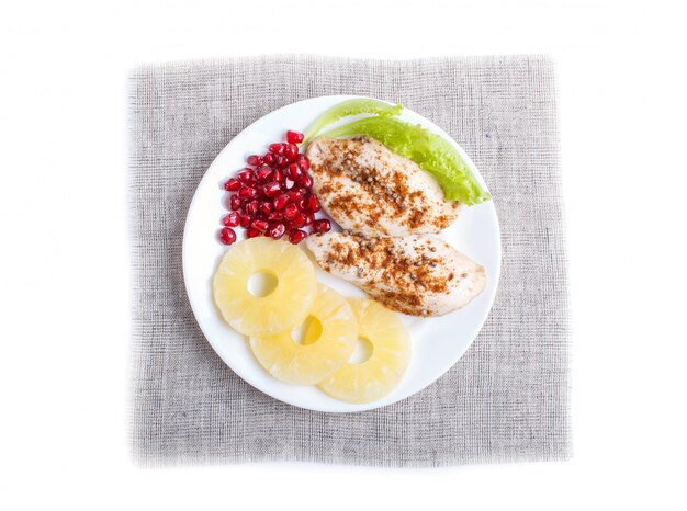 Fried chicken fillets with lettuce, pineapple and pomegranate seeds