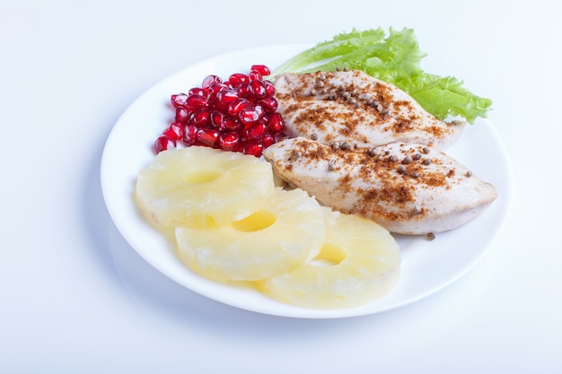 Fried chicken fillets with lettuce, pineapple and pomegranate seeds