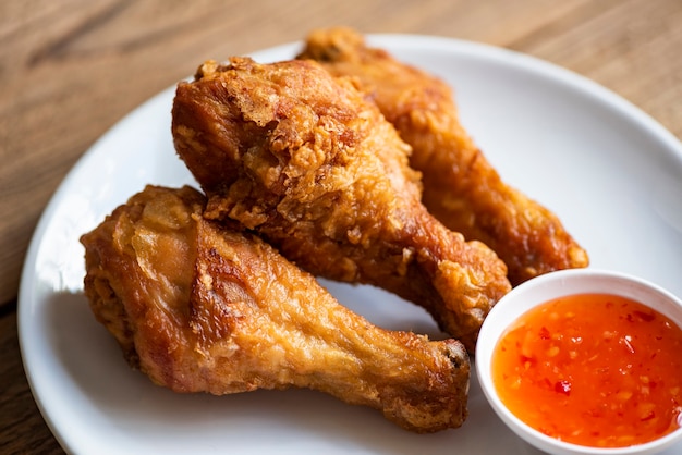 Fried chicken leg on plate with chicken dipping sauce, crispy fried chicken in a table food